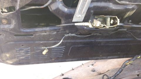 1994 Ford Bronco - Close-up of a car's interior door panel, revealing the window regulator and latch assembly.