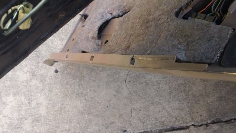1994 Ford Bronco - The interior panel of a vehicle is shown with exposed insulation and wiring, resting on a concrete surface.