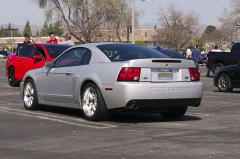 2006 Cadillac STS - A silver Ford Mustang Cobra is parked in a lot with other vehicles nearby.