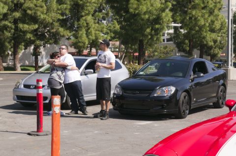 2006 Cadillac STS - A black coupe is parked next to a silver sedan, with people standing between them.