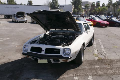 2006 Cadillac STS - White 1975 Pontiac Firebird with hood open at an outdoor car meet.