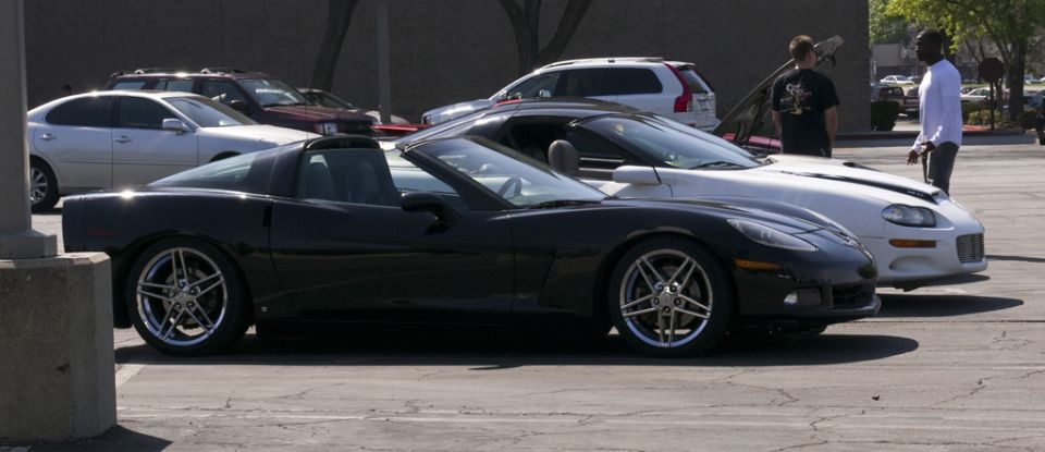 Black Chevrolet Corvette C6 convertible parked next to a white Chevrolet Camaro
