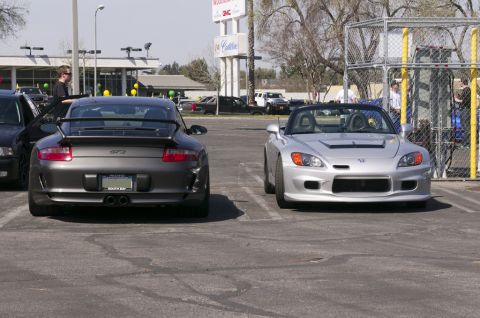 2006 Cadillac STS - A grey Porsche 911 GT3 is parked next to a silver convertible sports car.