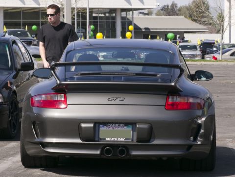 2006 Cadillac STS - Gray Porsche 911 GT3 seen from the rear, with a man standing nearby.