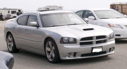 2006 Cadillac STS - Silver Dodge Charger SRT8 seen from the front-three-quarter angle.