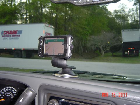 2005 Chevrolet Silverado 1500 - Interior view of a 2005 Chevrolet Silverado 1500 showing the dashboard and a GPS unit, with a moving truck in the background.