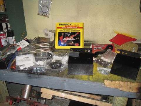 1979 Ford Bronco - Various suspension components and tools are laid out on a workbench.