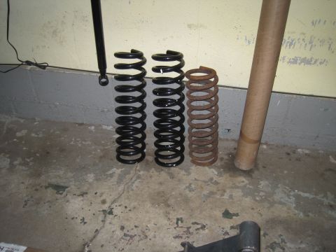 1979 Ford Bronco - Comparison of suspension springs, showing two new black springs and one old rusty spring.