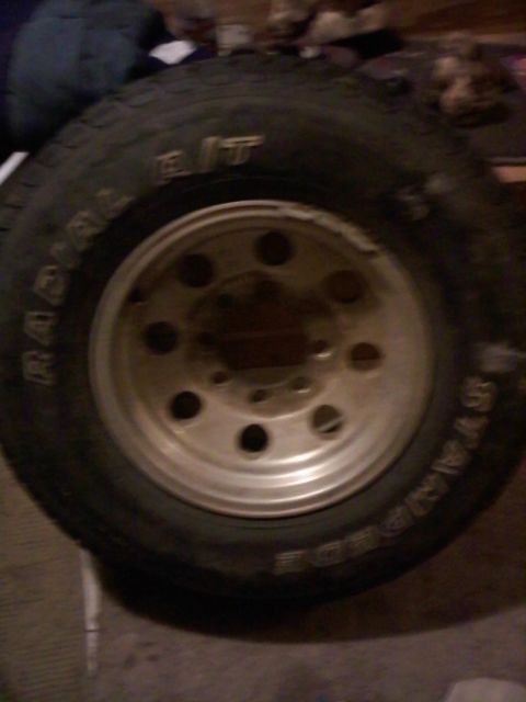 1990 Ford Bronco - A close-up shows a tire with 'RADIAL B/T' text and a silver 5-lug wheel.
