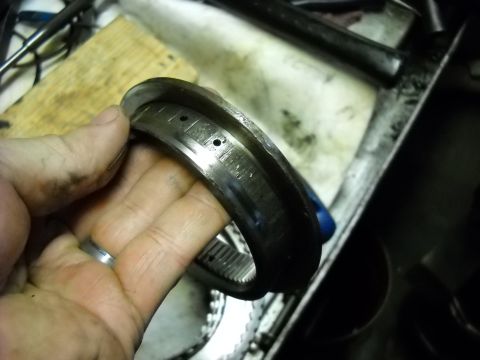 1993 Ford C-150 (Centurion Conversions) - A mechanic holds a worn transmission component, likely from an E4OD rebuild, showing significant wear.