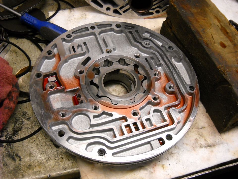 Metal automatic transmission valve body with orange fluid residue and a splined input shaft
