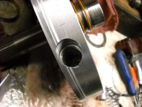 1993 Ford C-150 (Centurion Conversions) - A close-up view of a metal component, likely from a transmission, showing a threaded opening and machining details.