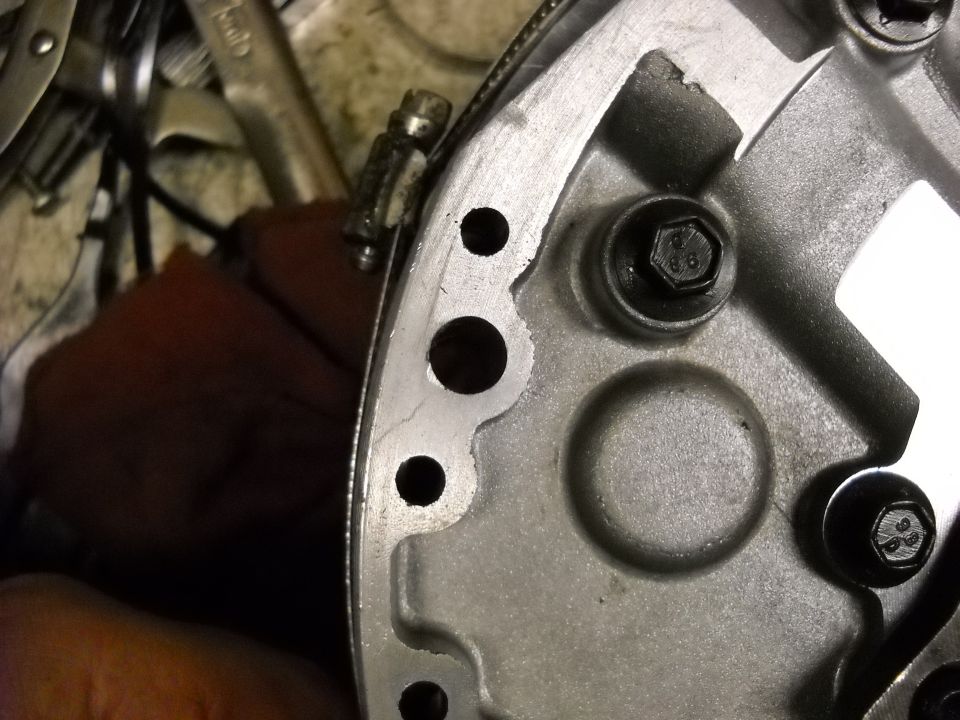 Close-up of transmission pump housing flange with 8.8-grade hex bolts