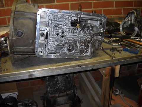 1993 Ford C-150 (Centurion Conversions) - Close-up of a disassembled automatic transmission valve body, showing its intricate internal passages.