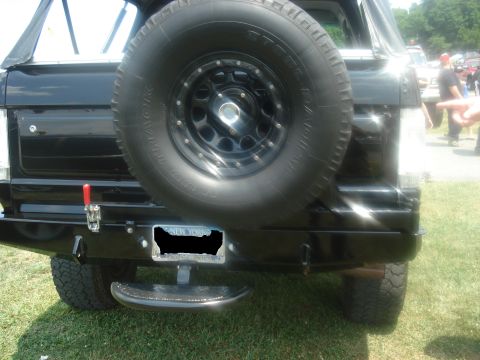 1988 Ford Bronco - The rear of a black SUV is shown, a spare tire and aftermarket bumper.