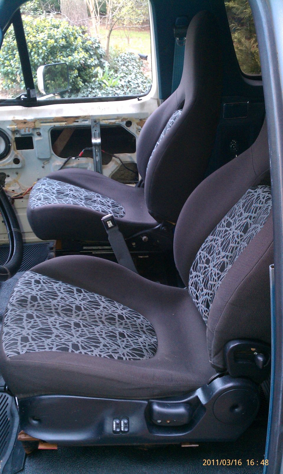 Interior view of aftermarket bucket seats with patterned inserts
