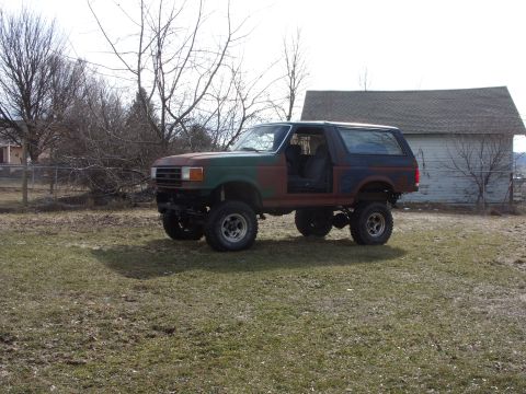 1988 Ford Bronco - This modified Ford Bronco sits in a yard with a rustic shed in the background.