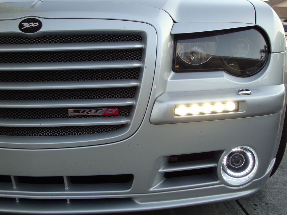 Chrysler 300 front corner detail: mesh grille, SRT8 badge, smoked headlight, LED lights