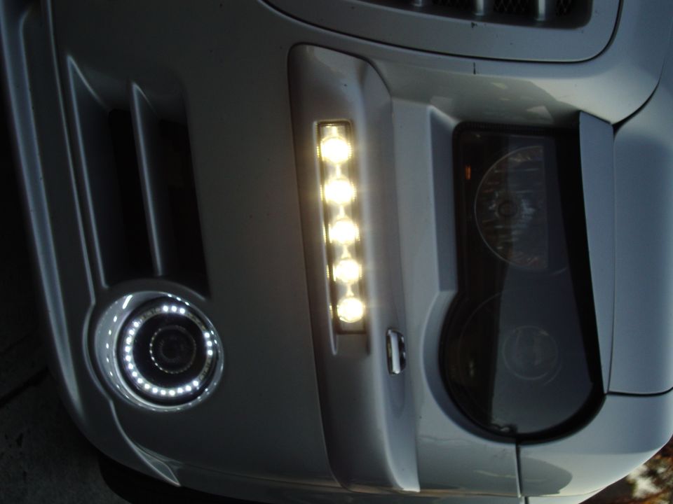 Close-up of silver Chrysler 300 bumper with LED daytime strip and halo-ringed fog light