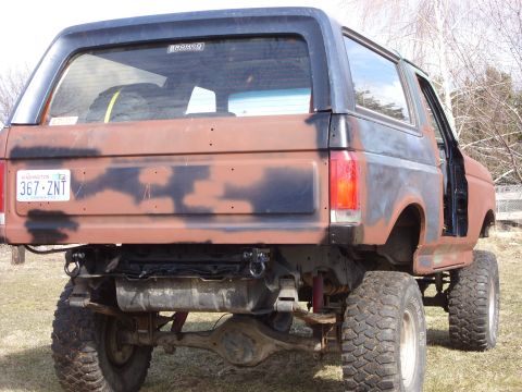 1988 Ford Bronco - This lifted Ford Bronco shows significant rust and a camouflage paint job.