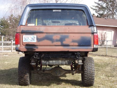 1988 Ford Bronco - Rear view of a 1988 Ford Bronco with custom paint and off-road modifications.