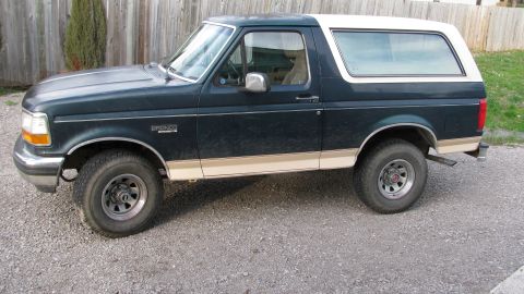 1992 Ford Bronco - Side view of a 1992 Ford Bronco, showing its two-tone paint scheme and off-road tires.