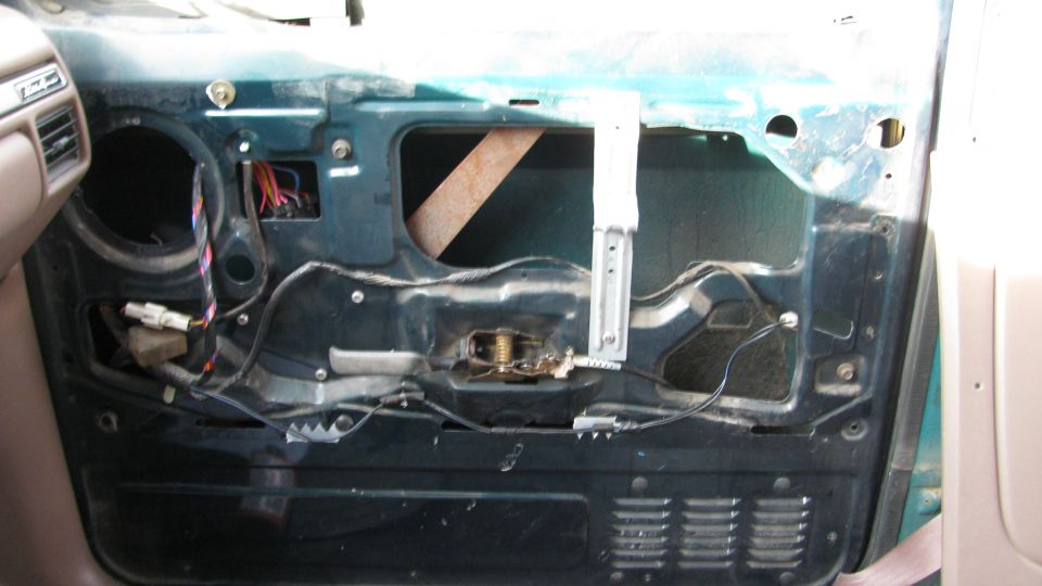 Interior door panel removed, showing window mechanism and wiring. 1992 Ford Bronco