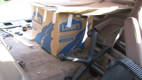1992 Ford Bronco - A Lowe's box and an office chair are stored in the back of a vehicle.