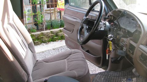 1992 Ford Bronco - The interior of a 1992 Ford Bronco shows signs of wear and tear, with exposed dashboard components and faded upholstery.