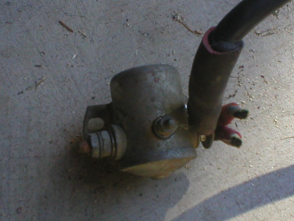 Starter solenoid with thick black cable and red wire connectors