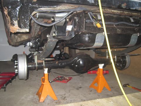 1979 Ford Bronco - Underside view of a vehicle's rear axle and suspension system during maintenance.