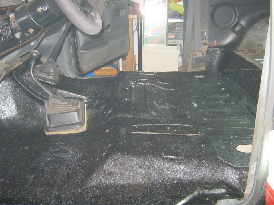 Carpeted vehicle floor and footwell with manual shifter