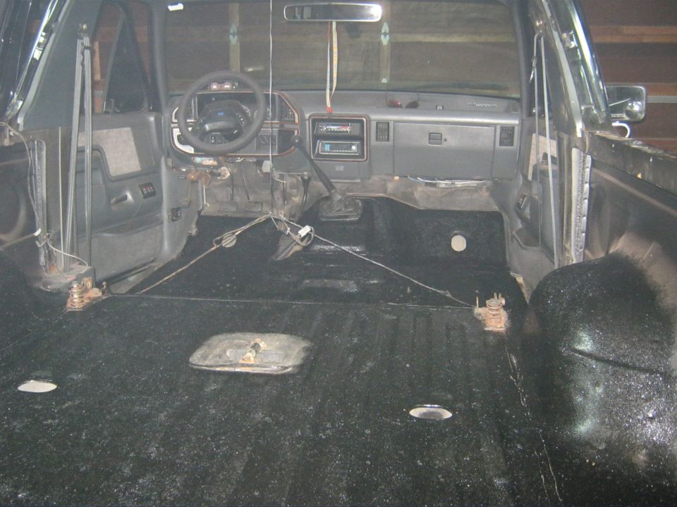 Gutted vehicle interior with bare floor, dash and steering wheel