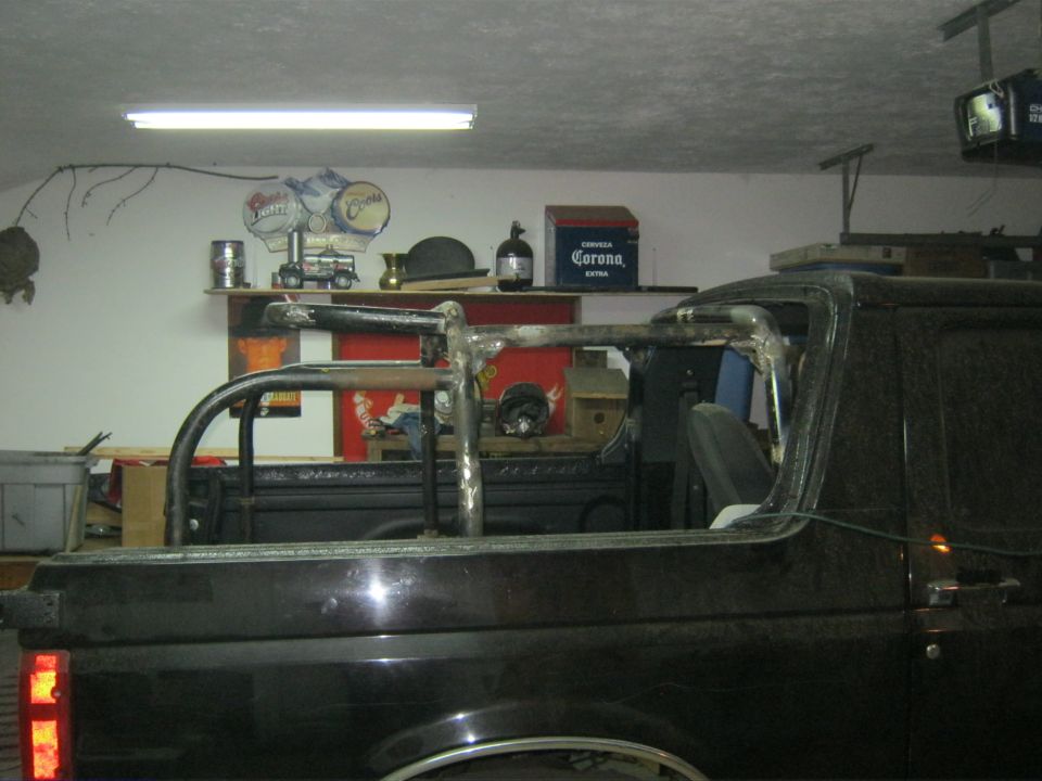 Black pickup or SUV bed with a roll bar mounted, in a garage