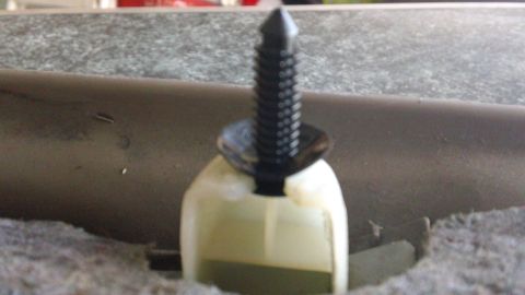 1994 Ford Bronco - Close-up of a black plastic trim clip and its white fastener.