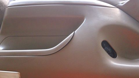 1994 Ford Bronco - Close-up of a vehicle's interior door panel, showing a storage compartment and a vent.