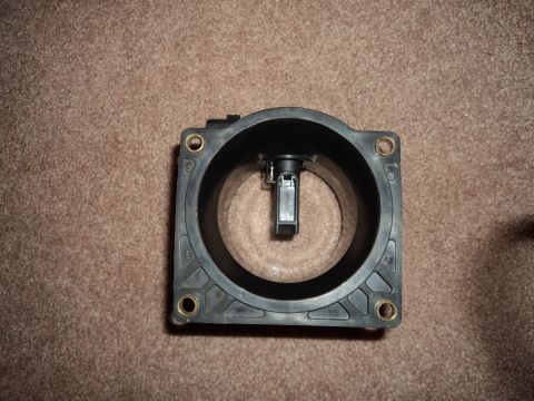 2004 Mercury Grand Marquis - A black mass air flow sensor is shown against a brown carpet background.
