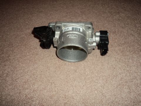 2004 Mercury Grand Marquis - A Ford throttle body sits on a carpeted surface.