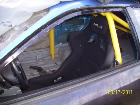 1995 Ford Probe - Interior view of a car modified with a racing seat and roll cage, dated 03/17/2011.