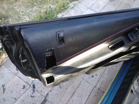 1995 Ford Probe - Interior door panel with damage and cutouts, likely for aftermarket modifications.