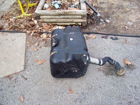 1989 Ford Bronco - A detached fuel tank with a flexible hose is shown on the ground, likely removed for body work.
