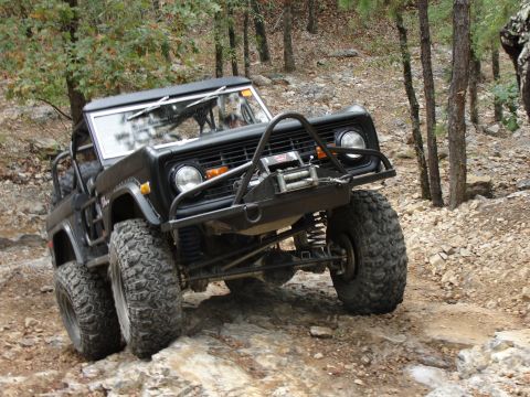 1967 Ford Mustang - This black Ford Bronco is navigating a challenging rocky terrain on an off-road trail.