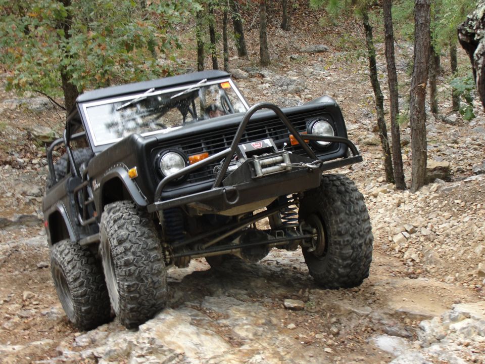 Black Ford Bronco off-roading on a rocky trail, front 3/4 view