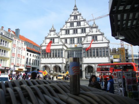 1999 Lincoln Town Car - A red double-decker bus is visible in a European town square with historic architecture.