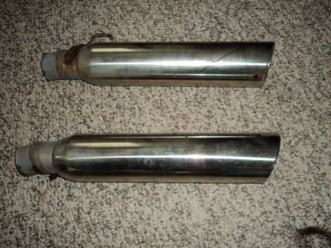 2004 Mercury Grand Marquis - A pair of chrome exhaust tips are shown, one with a visible clamp and rust.