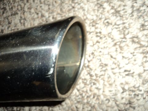 2004 Mercury Grand Marquis - Close-up of a chrome exhaust pipe tip, showing wear and tear on its surface.