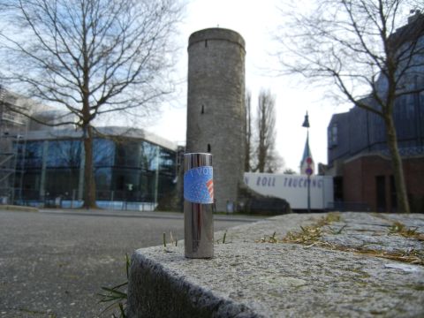 1999 Lincoln Town Car - A lighter with a patriotic sticker is placed on a stone in front of a tower and a modern building.