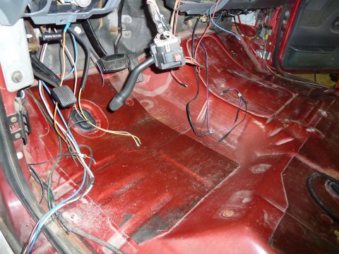 1993 Ford C-150 (Centurion Conversions) - The interior floor of a vehicle shows exposed wiring and pedals, with a brake release lever visible.