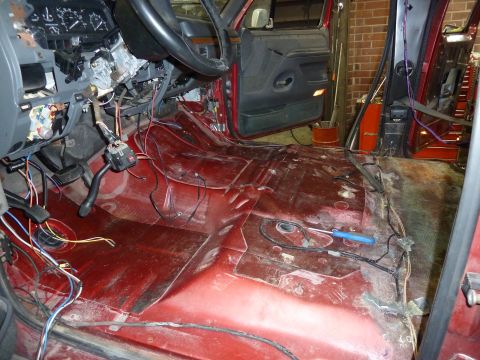 1993 Ford C-150 (Centurion Conversions) - The interior of a red truck shows exposed wiring and a disassembled dashboard, indicating ongoing work.