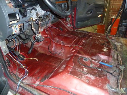 1993 Ford C-150 (Centurion Conversions) - Interior of a vehicle undergoing work, with flooring removed and wiring exposed.